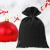 Bola de Navidad roja junto a una bolsa de terciopelo negro para regalos.